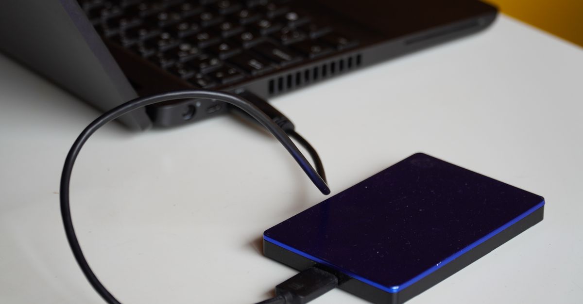 External hard drive connected to a laptop, showcasing portable storage solution.