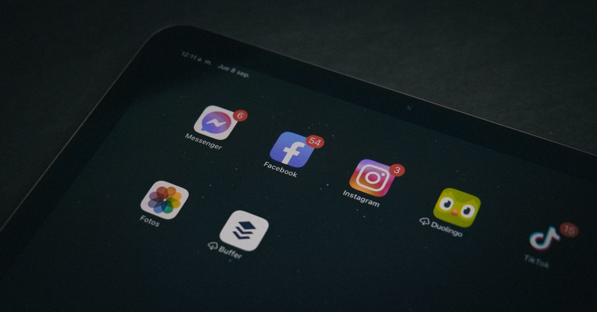 A tablet displaying popular apps like Facebook and Instagram in a dimly lit setting.