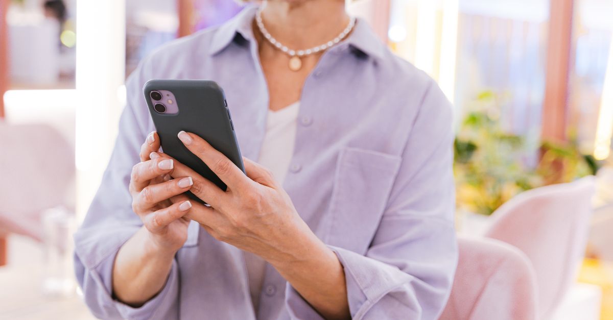 Frau hält ein Smartphone in beiden Händen, zum Thema Foto-Tresor für private Fotos.