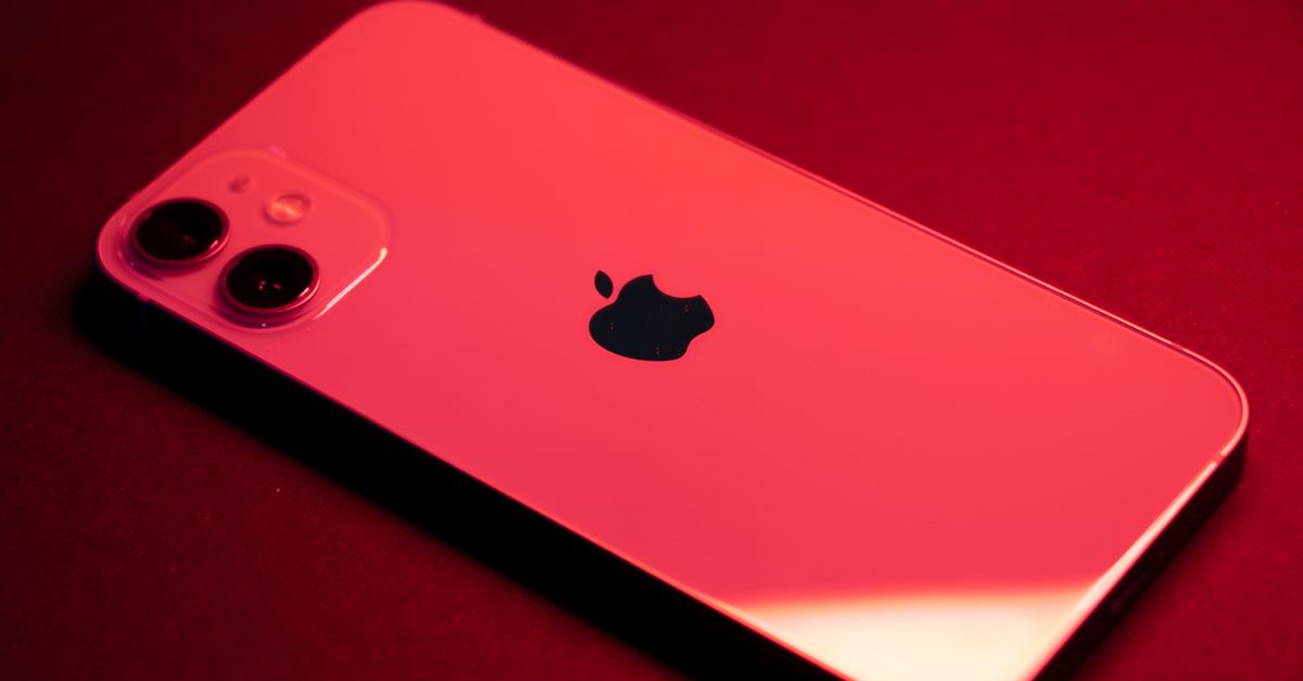 Close-up of a red smartphone with dual lenses on a red backdrop, highlighting sleek design and technology.