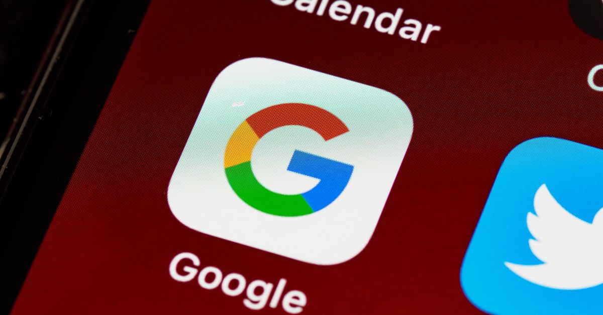 Macro view of a smartphone displaying Google and other app icons on the home screen.
