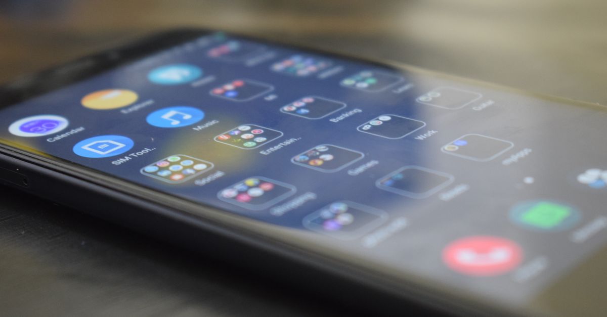 Close-up shot of a smartphone screen showing various app icons, indicating digital technology use.
