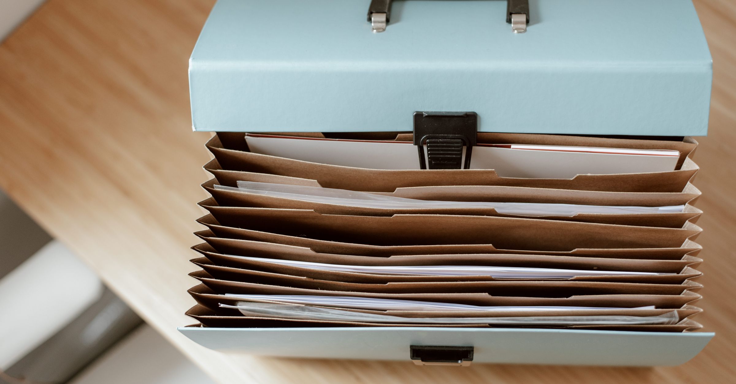 Open accordion file box filled with paper documents, illustrating files kept behind a password or PIN.