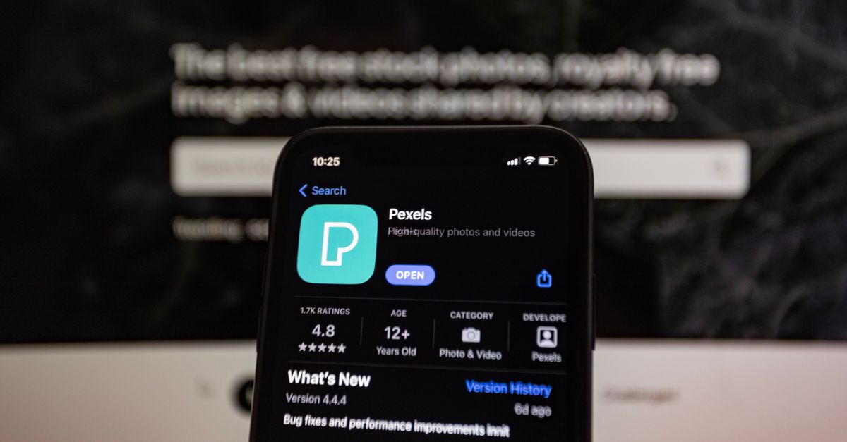 Close-up of a smartphone screen displaying the Pexels app with a blurred background.