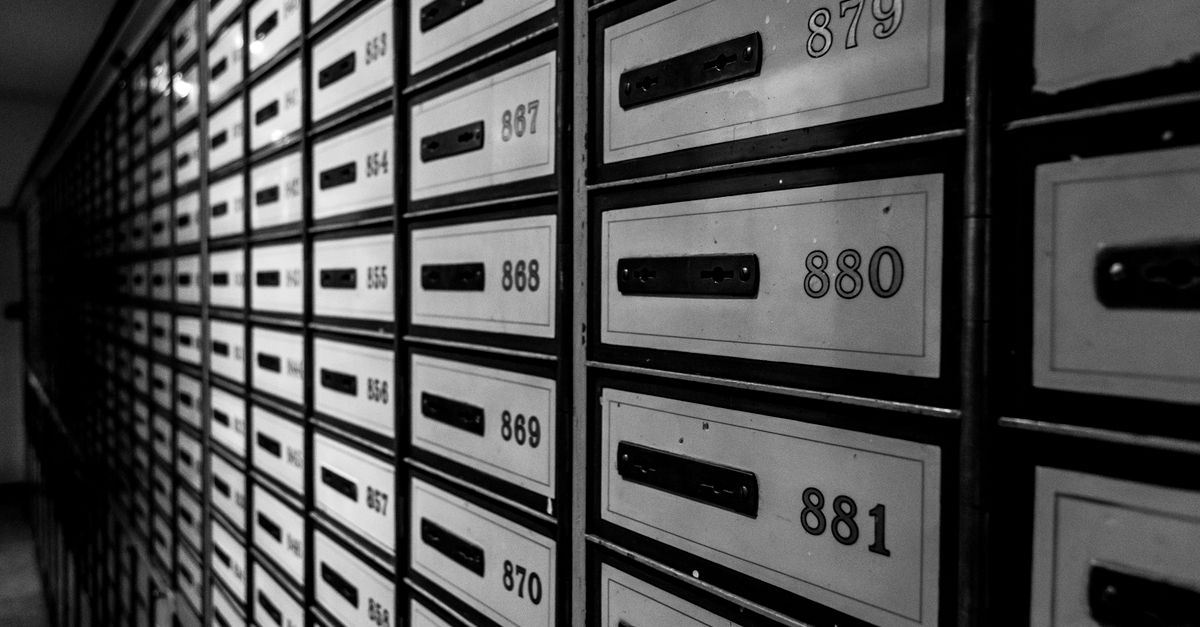 A striking black and white image featuring rows of organized mailboxes in a building interior.