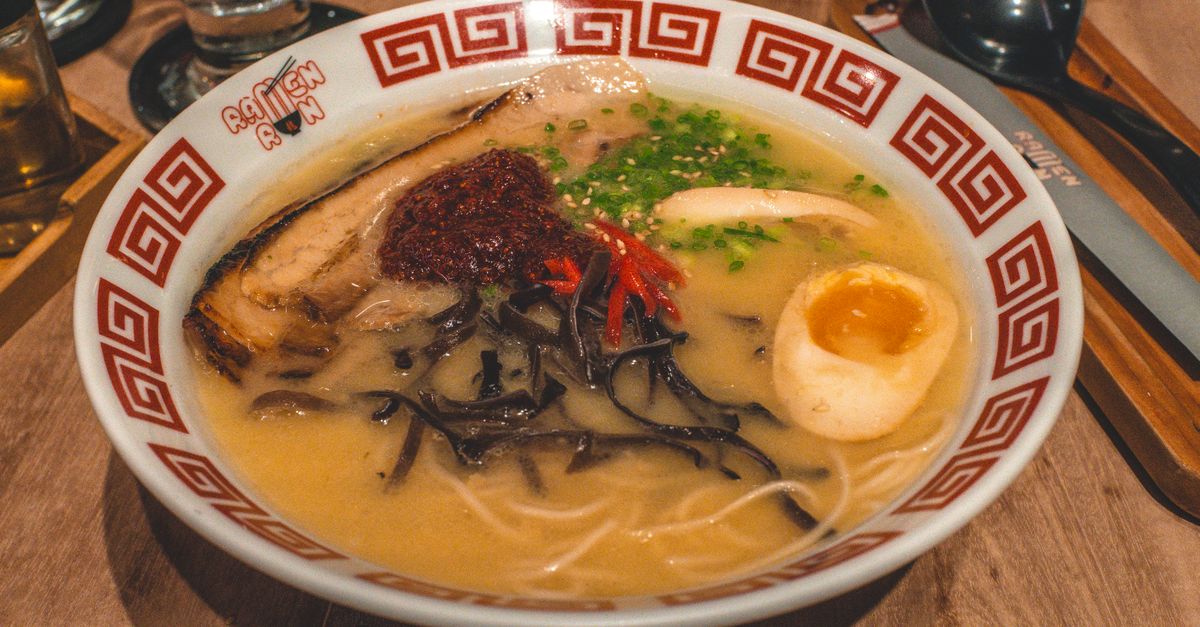 Close-up of traditional Japanese ramen with toppings in a restaurant setting.