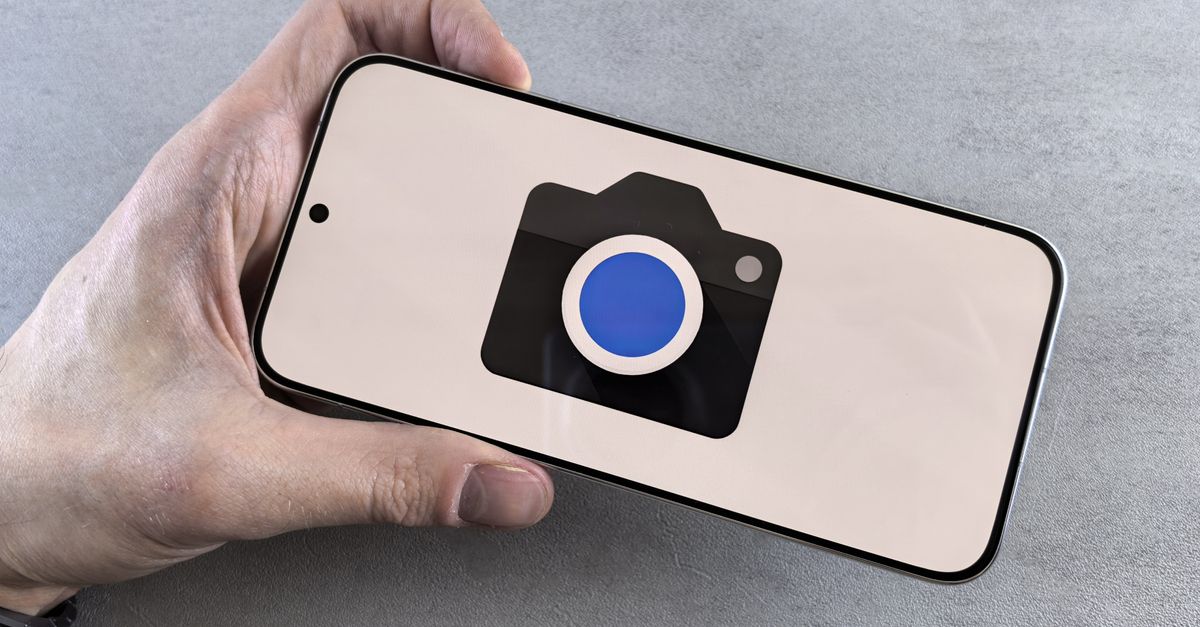 Close-up of a hand holding a smartphone displaying a camera icon, ideal for tech-related content.