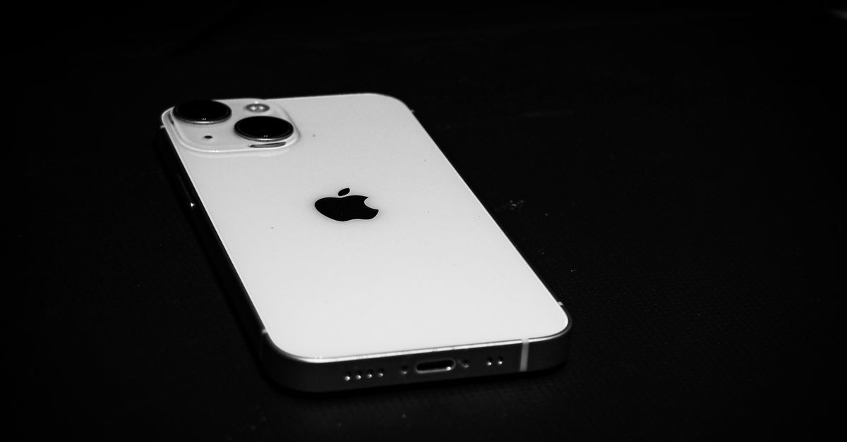 Elegant black and white photo of a smartphone on a dark surface, emphasizing sleek design.