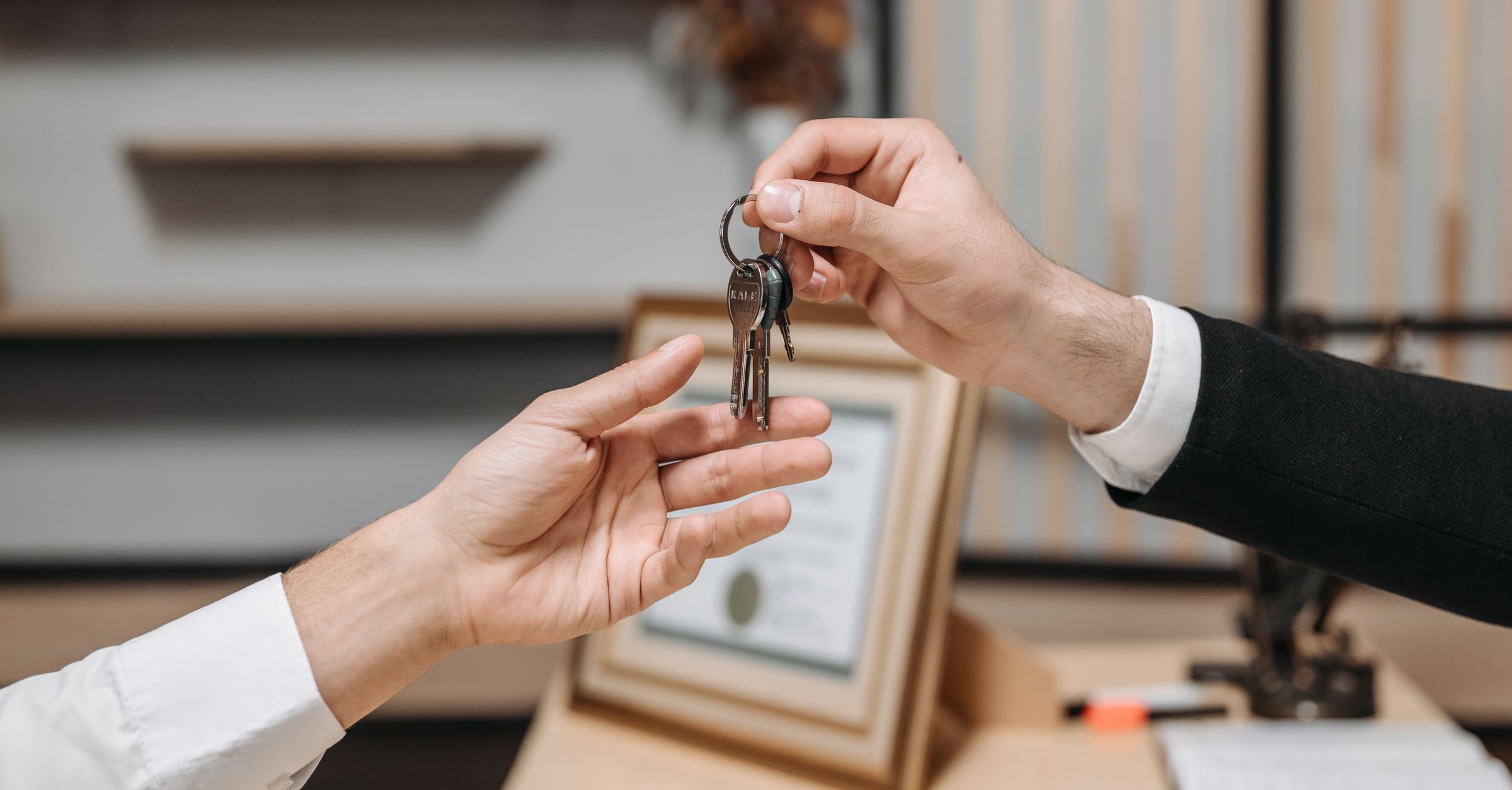Hands exchanging house keys as a visual metaphor for Legacy Contact and private photo inheritance.