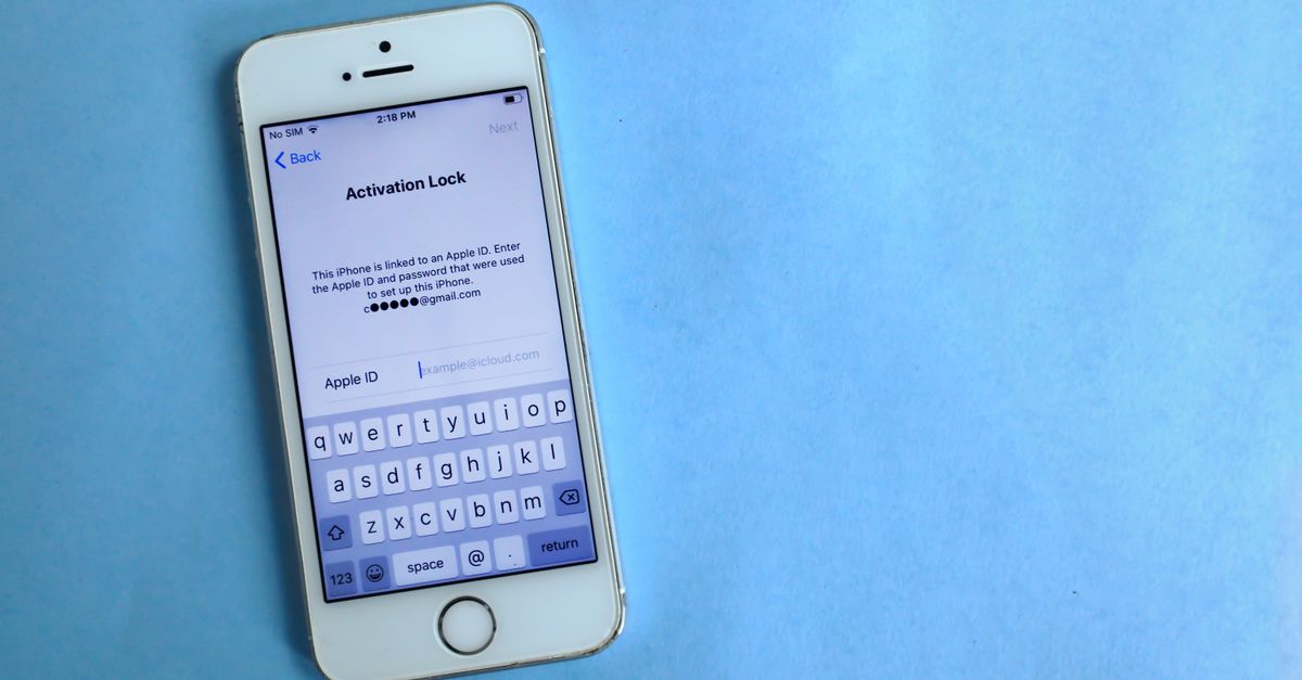 Top view of a smartphone showing activation lock screen on light blue surface.