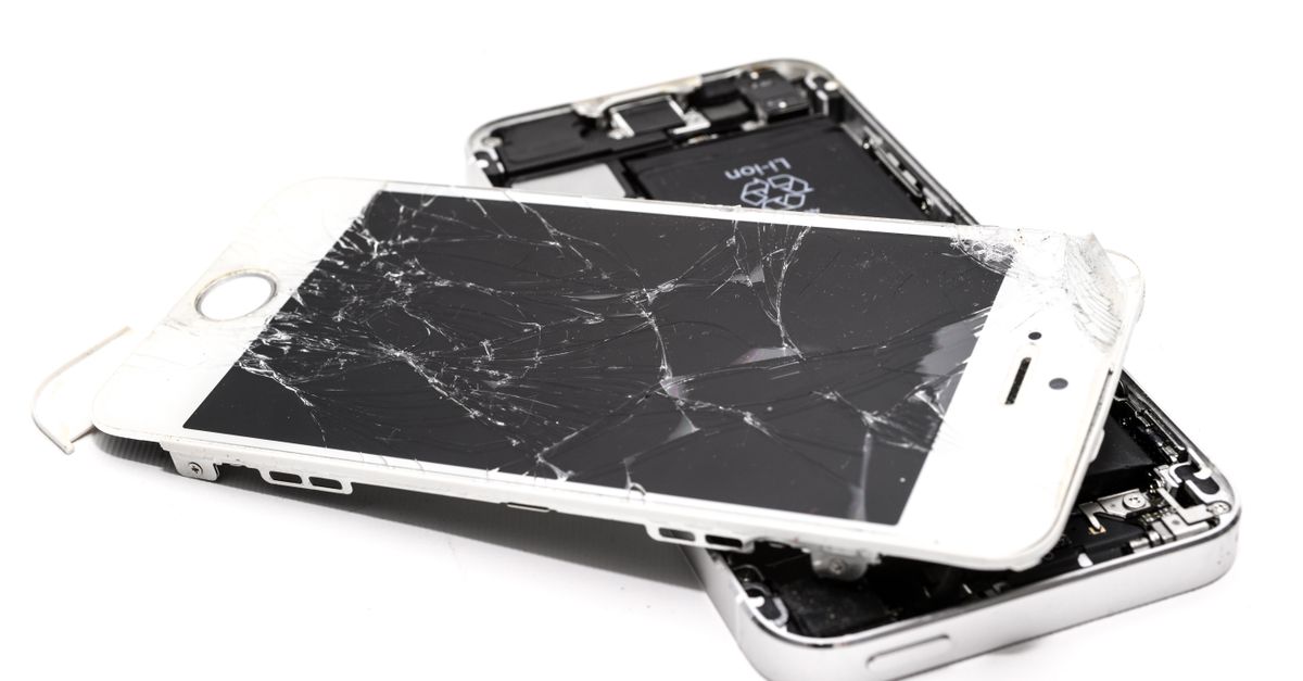 Close-up of a broken smartphone with a severely cracked screen.