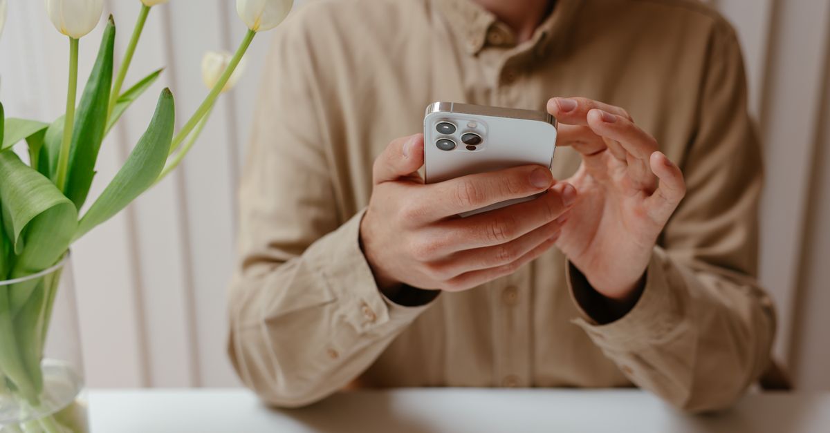 坐在桌前操作 iPhone，對應相簿上鎖的日常使用情境。
