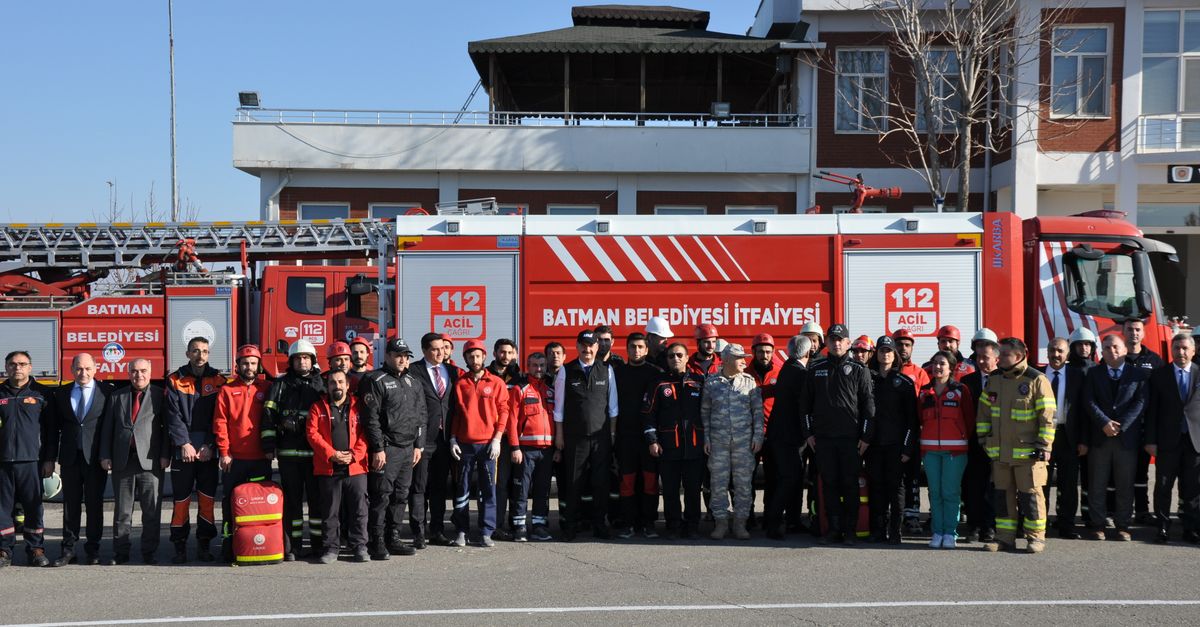 Group of firefighters and officials posing in front of a fire truck in Batman, Türkiye.