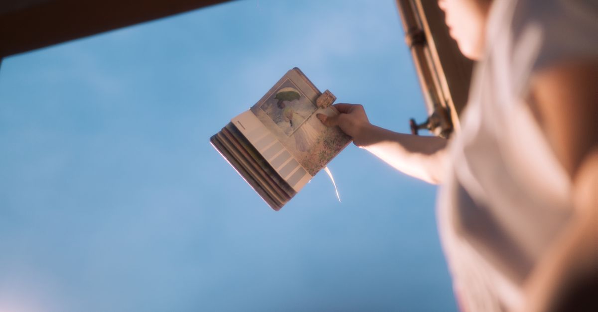 Young adult reading book outdoors against a gentle blue sky in Lạng Sơn, Việt Nam.