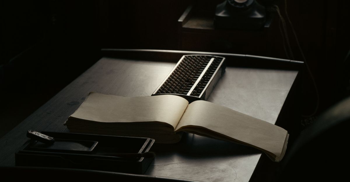 A nostalgic scene of a vintage desk with an open book, typewriter, and rotary phone.